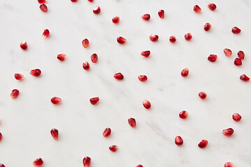 Image showing Horizontal pattern from fresh juicy natural pomegranate seeds on a marble background.