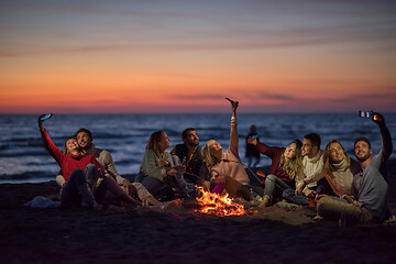 Image showing a group of friends enjoying bonfire on beach