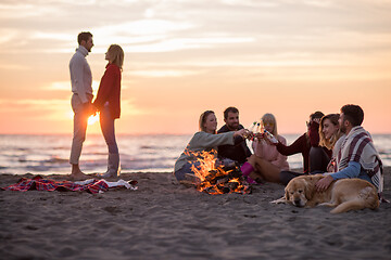 Image showing Couple enjoying with friends at sunset on the beach