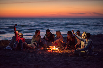 Image showing a group of friends enjoying bonfire on beach