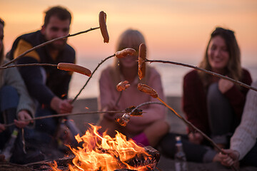 Image showing Group Of Young Friends Sitting By The Fire at beach