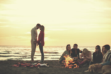 Image showing Couple enjoying with friends at sunset on the beach