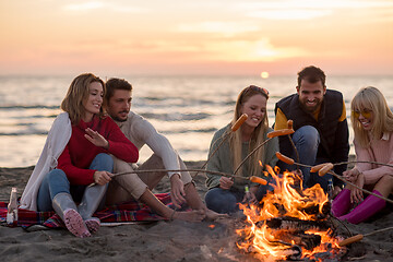 Image showing Group Of Young Friends Sitting By The Fire at beach