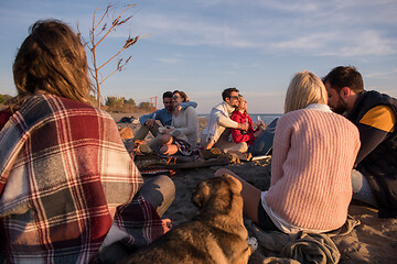 Image showing Couple enjoying with friends at sunset on the beach