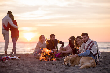 Image showing Couple enjoying with friends at sunset on the beach