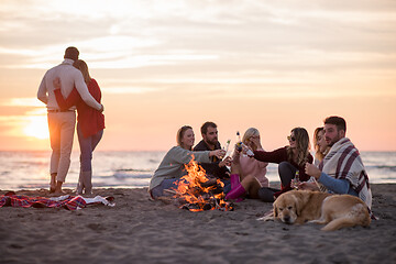 Image showing Couple enjoying with friends at sunset on the beach