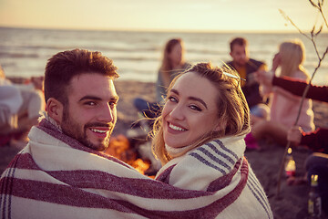 Image showing Couple enjoying with friends at sunset on the beach