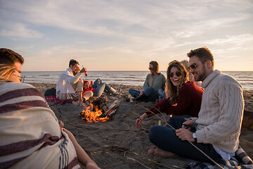 Image showing Couple enjoying with friends at sunset on the beach