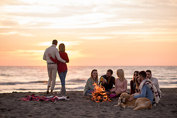 Image showing Couple enjoying with friends at sunset on the beach