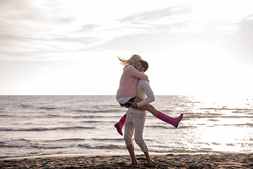 Image showing Loving young couple on a beach at autumn sunny day