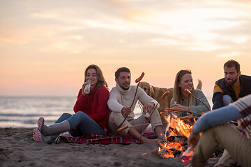 Image showing Group Of Young Friends Sitting By The Fire at beach