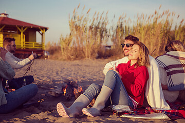 Image showing Couple enjoying with friends at sunset on the beach