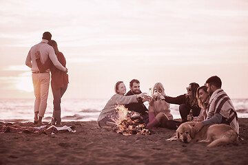 Image showing Couple enjoying with friends at sunset on the beach