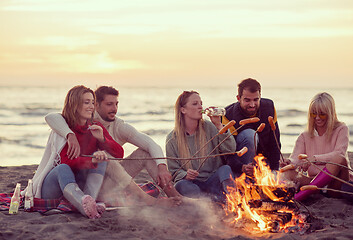 Image showing Group Of Young Friends Sitting By The Fire at beach