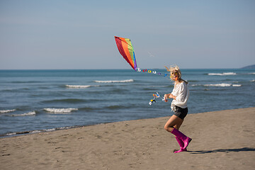 Image showing Young Woman with kite at beach on autumn day