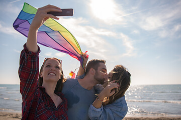 Image showing Group of friends making selfie on beach during autumn day