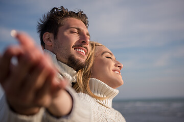 Image showing Loving young couple on a beach at autumn sunny day