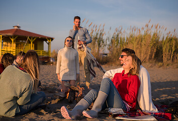 Image showing Couple enjoying with friends at sunset on the beach