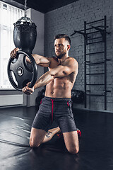 Image showing The athlete trains hard in the gym. Fitness and healthy life concept.