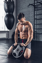 Image showing The athlete trains hard in the gym. Fitness and healthy life concept.