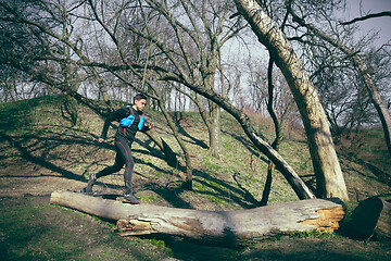 Image showing Man running in a park or forest against trees background.