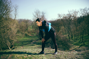 Image showing Man after running in a park or forest against trees background.