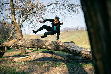 Image showing Man running in a park or forest against trees background.