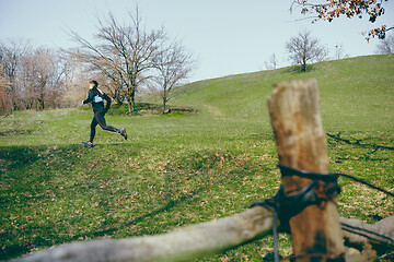 Image showing Man running in a park or forest against trees background.