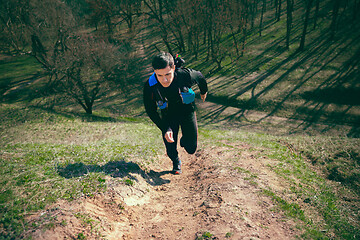 Image showing Man running in a park or forest against trees background.