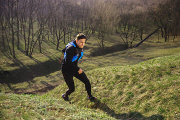 Image showing Man running in a park or forest against trees background.