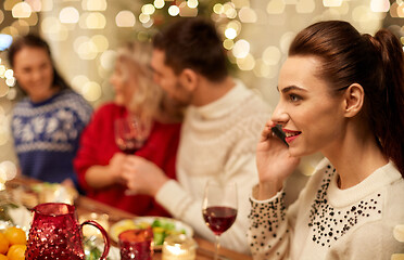 Image showing woman calling on smartphone at christmas dinner