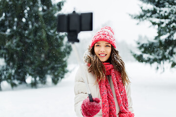 Image showing young woman taking selfie by monopod in winter