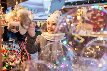 Image showing little girl choosing christmas balls at market