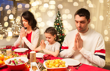 Image showing family praying before meal at christmas dinner