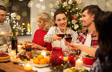 Image showing happy friends drinking red wine at christmas party