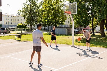 Image showing group of male friends playing street basketball