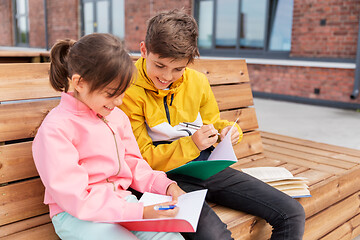 Image showing school children with notebooks sitting on bench