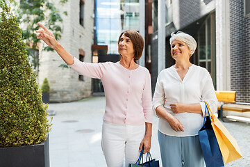 Image showing senior women with shopping bags walking in city