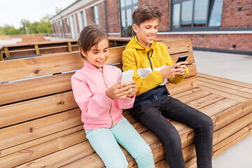 Image showing children with smartphones sitting on street bench