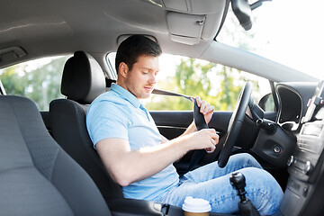 Image showing man or car driver fastening seat belt