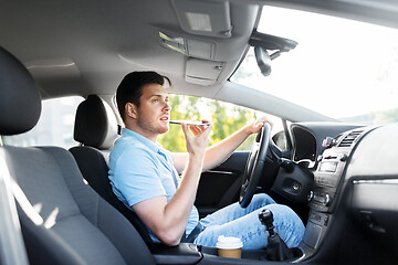 Image showing man driving car and recording voice by smartphone