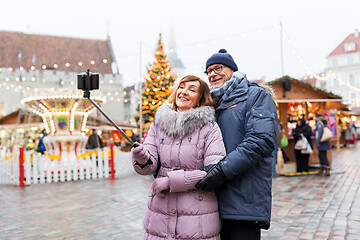 Image showing senior couple taking selfie at christmas market