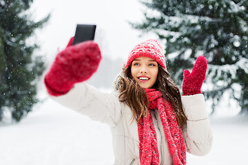 Image showing young woman taking selfie by smartphone in winter