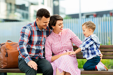 Image showing happy family sitting on street bench in city