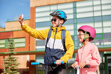 Image showing happy school kids with scooters taking selfie