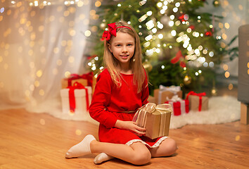 Image showing smiling girl with christmas gift at home