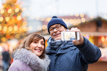 Image showing senior couple taking selfie at christmas market