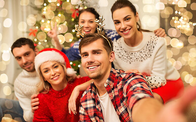 Image showing friends celebrating christmas and taking selfie