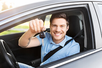 Image showing smiling man or driver with key sitting in car