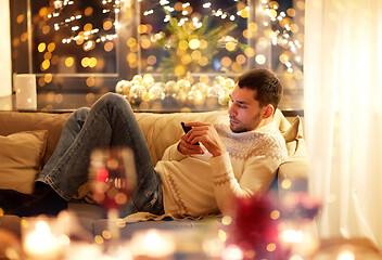 Image showing man with smartphone at home at christmas eve